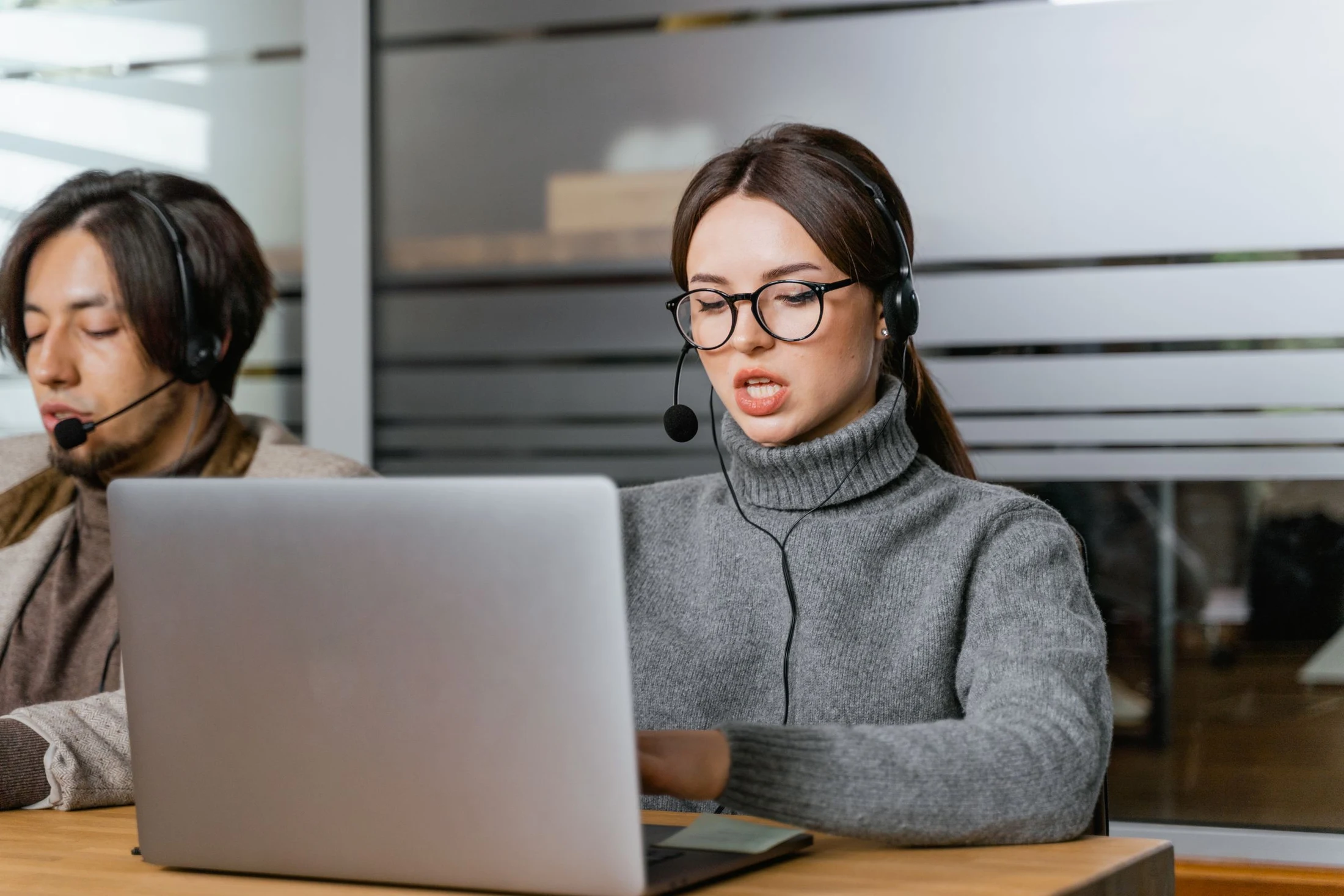 Support specialist wearing a headset and working at a laptop