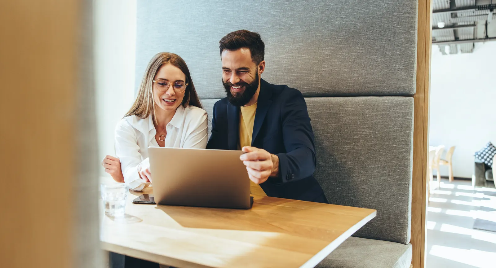 Two professionals validating information together at a laptop