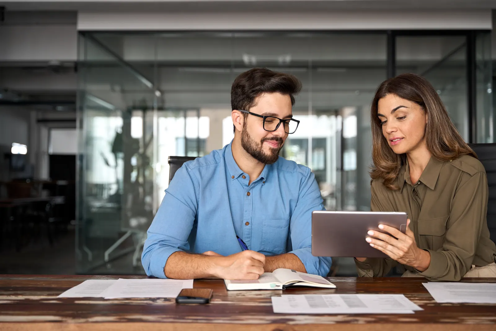 Two colleagues checking service information on a tablet at a table
