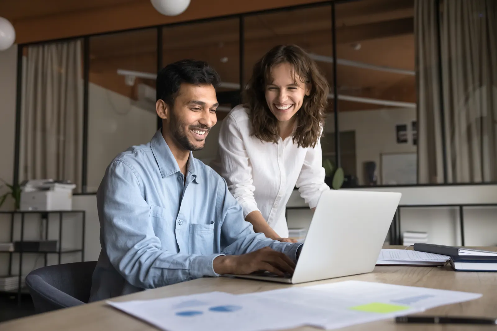 Two colleagues reviewing a task together at a laptop