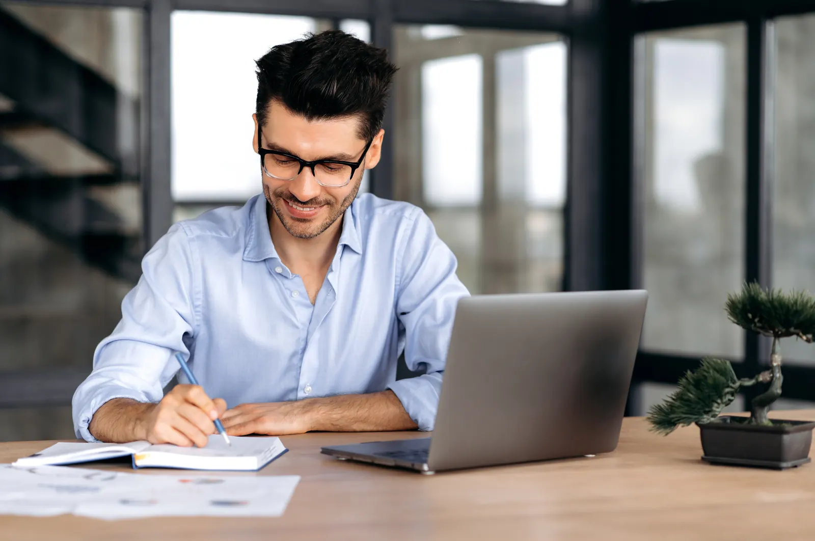 Analyst checking written customer criteria against information on a laptop