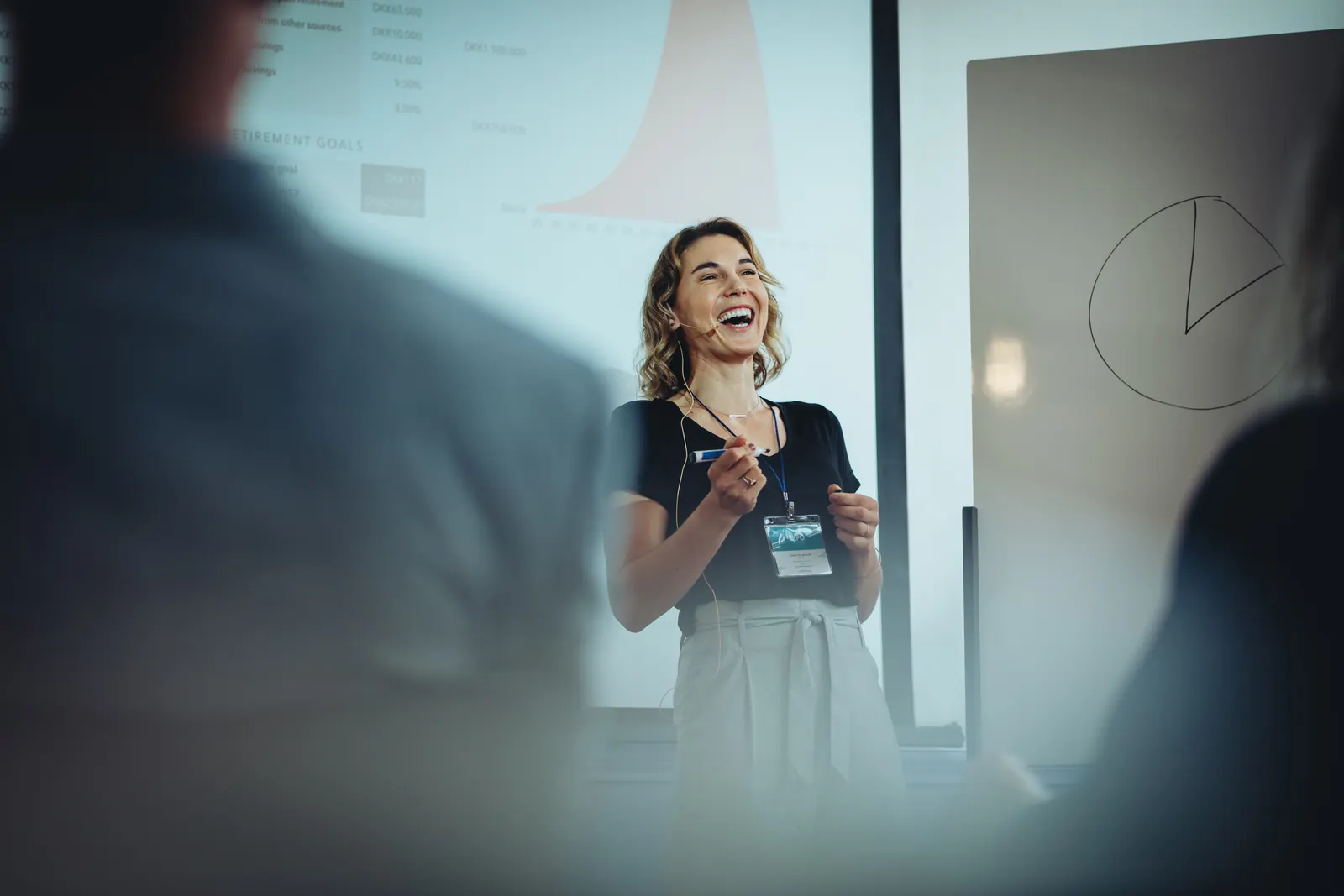 A colleague leading a workshop beside a whiteboard while others listen