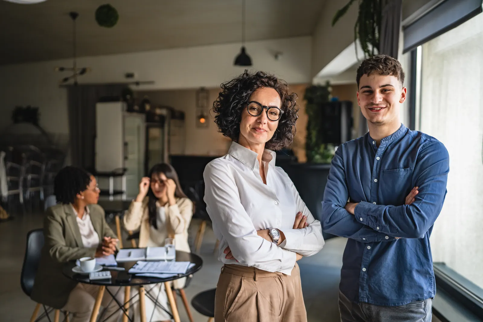 Two specialists standing together in front of their project workspace