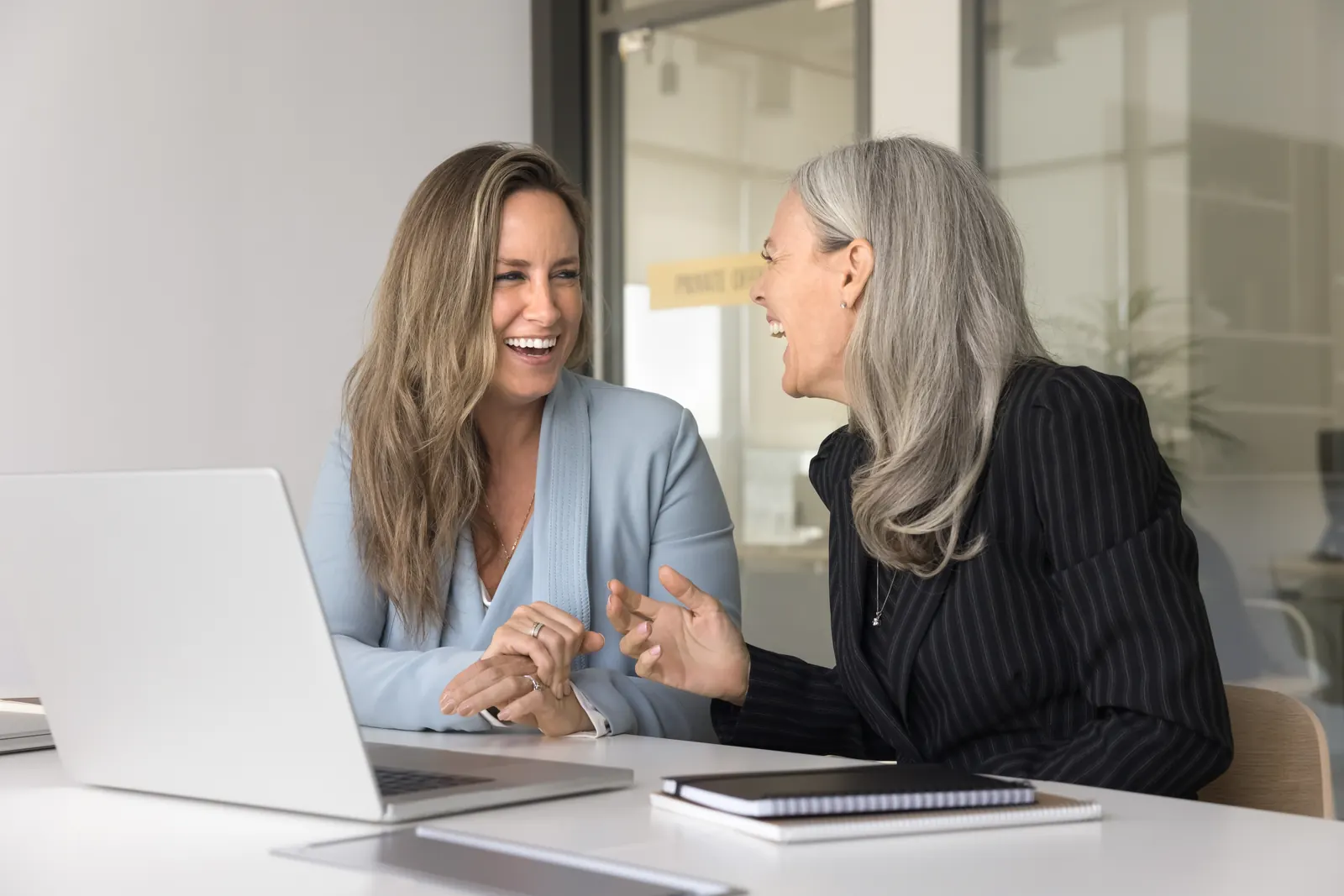 Two professionals examining information together on a laptop