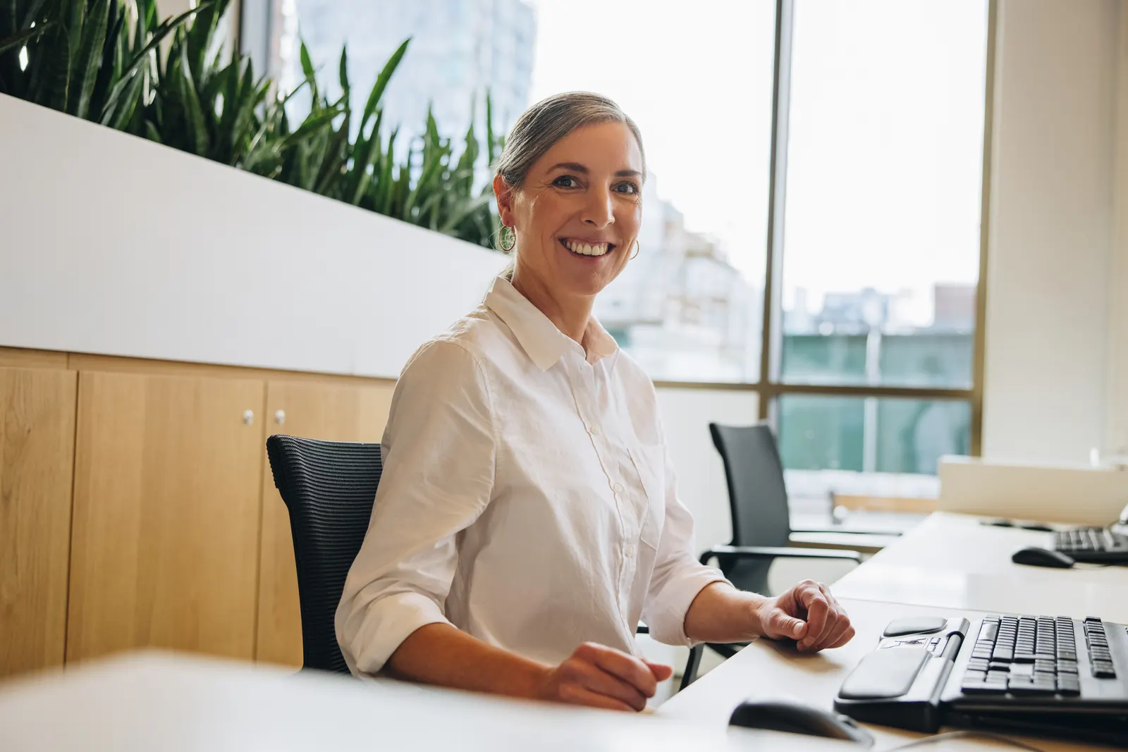 A professional seated at a computer keyboard in a bright office