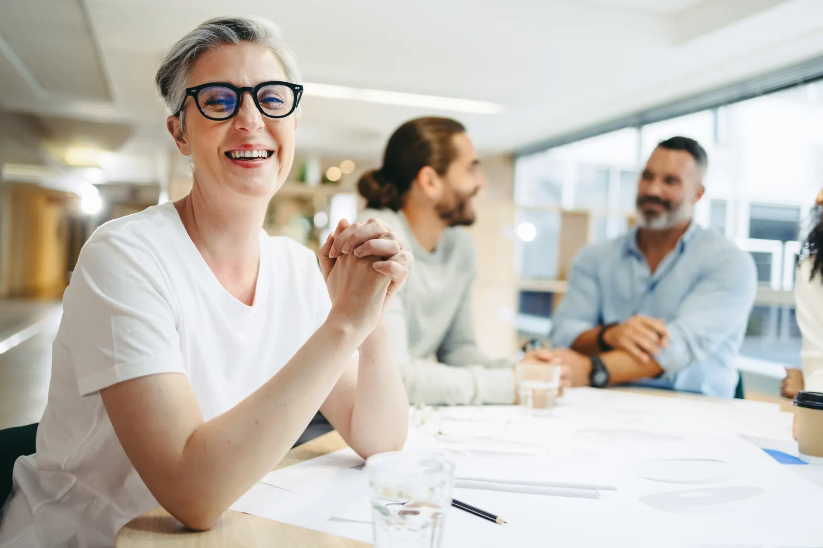 A cross-functional team discussing work together around an office table