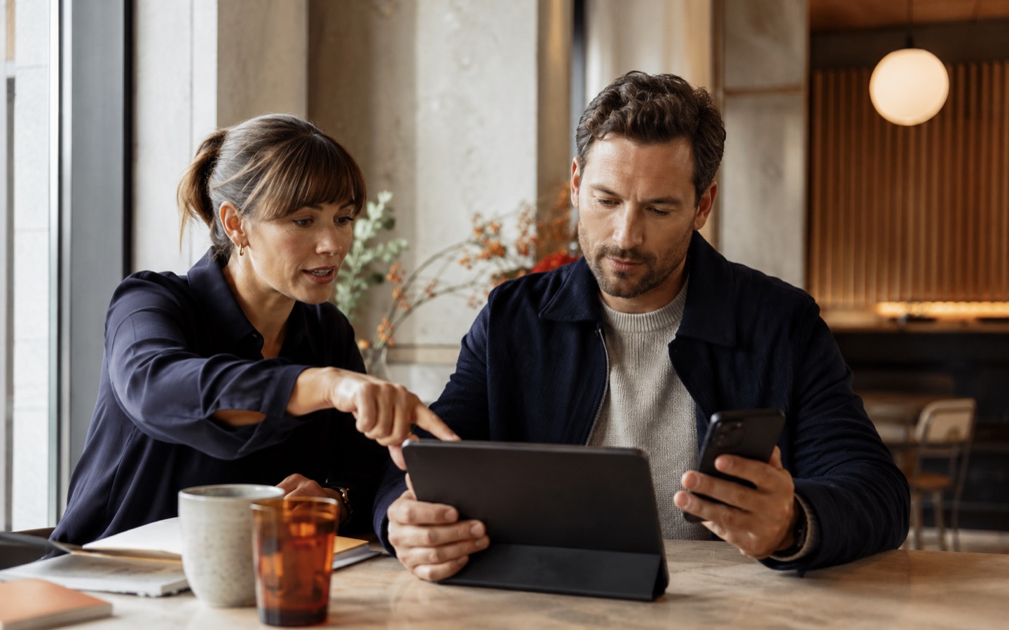 Colleagues simplifying a mobile CRM workflow on a tablet and phone